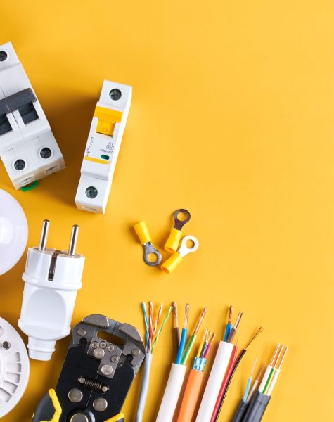 Electrical tools set with dimmer switch isolated on yellow background with copy space, controllable lighting. Saving energy concept, building and renovation